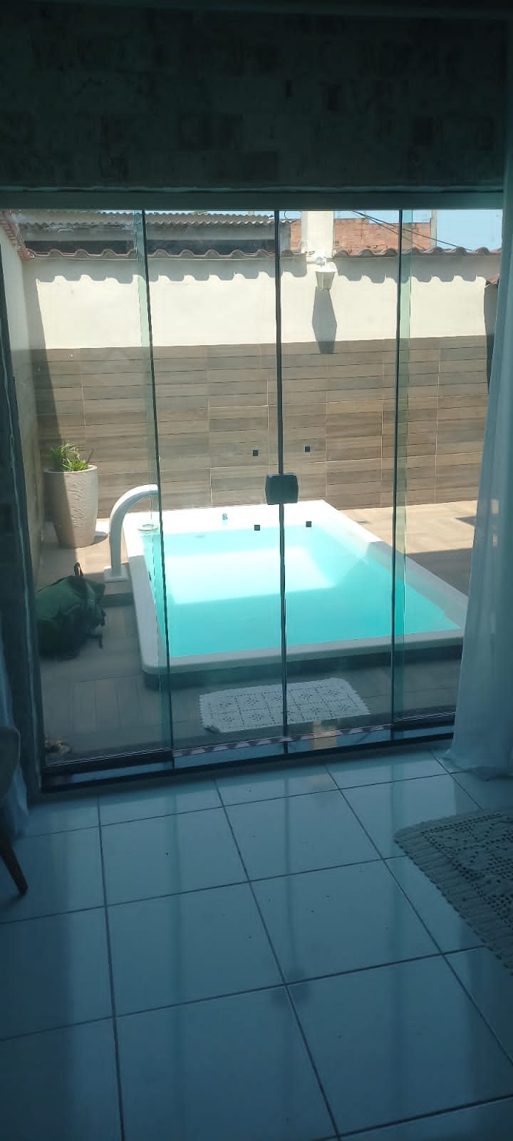 Fechamento de varanda em vidro com vista para piscina